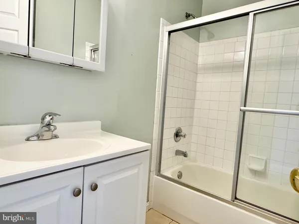 a bathroom with a tub sink and mirror