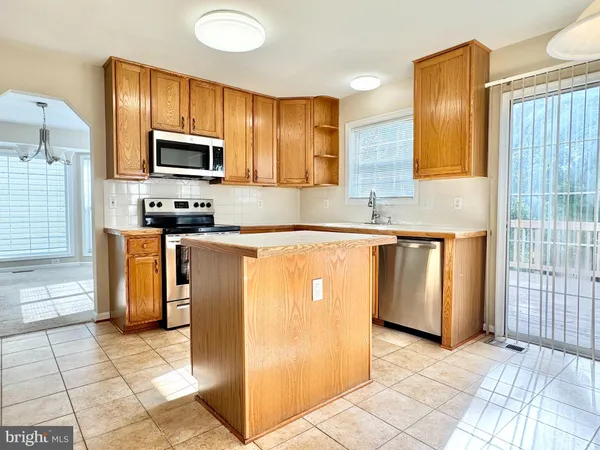 a kitchen with stainless steel appliances a sink a stove a microwave a counter top space and cabinets