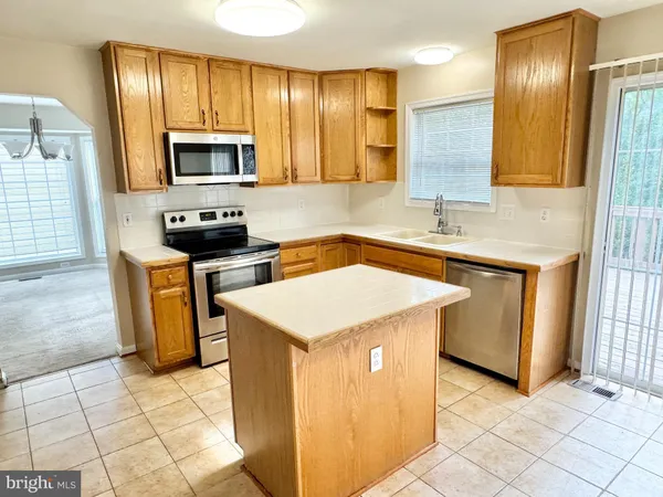 a kitchen with a sink a stove top oven and cabinetry