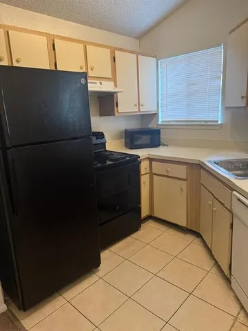 a kitchen with a refrigerator and cabinets