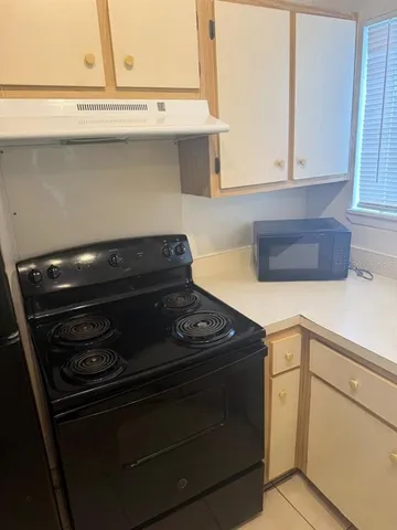 a stove top oven sitting inside of a kitchen