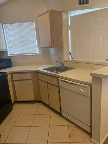 a kitchen with a sink cabinets and utility
