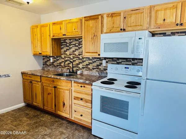 a kitchen with stainless steel appliances a stove a sink and a microwave