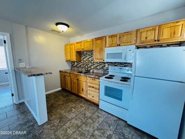 a kitchen with stainless steel appliances granite countertop a stove a refrigerator and a sink