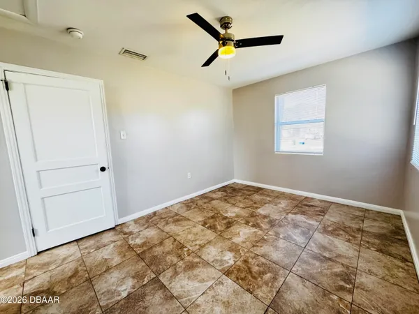 a view of a big room with wooden floor and a ceiling fan