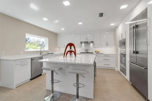 a kitchen with white cabinets and stainless steel appliances