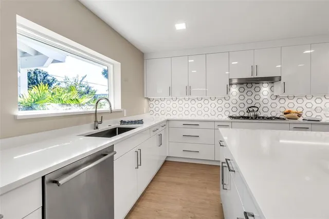 a kitchen with stainless steel appliances a stove a sink and a refrigerator