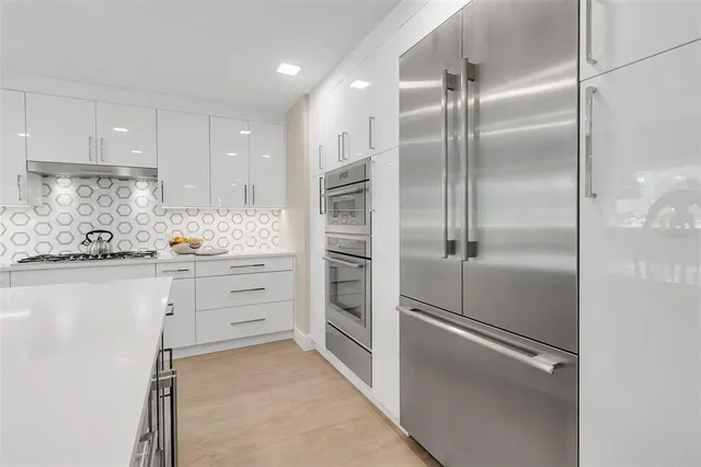 a view of a dining room and livingroom with furniture wooden floor a chandelier