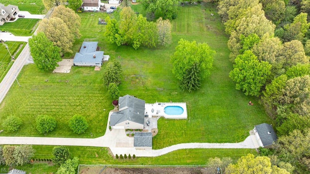 6787 South Palmyra Road Canfield, OH 44406 - Photo 3 of 30 Expansive green lawn with mature trees, featuring a main residence, a detached garage, a swimming pool with surrounding patio, and a lengthy paved driveway
