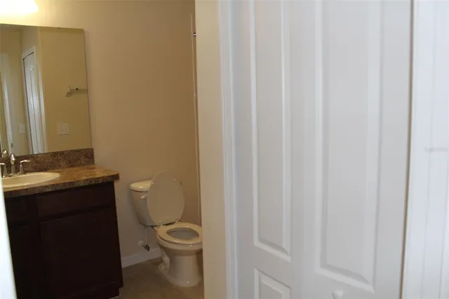 a bathroom with a granite countertop toilet and a sink
