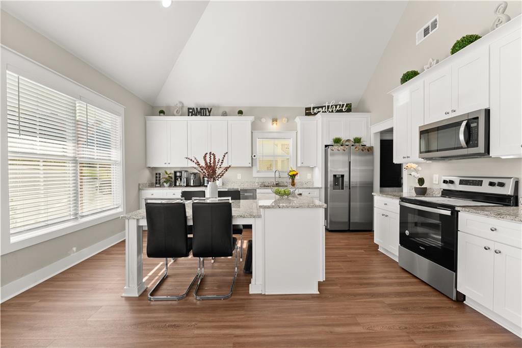 230 Campbell Street Cleveland, GA 30528 - Photo 8 of 37 a kitchen with stainless steel appliances a refrigerator a stove a sink cabinets and wooden floor