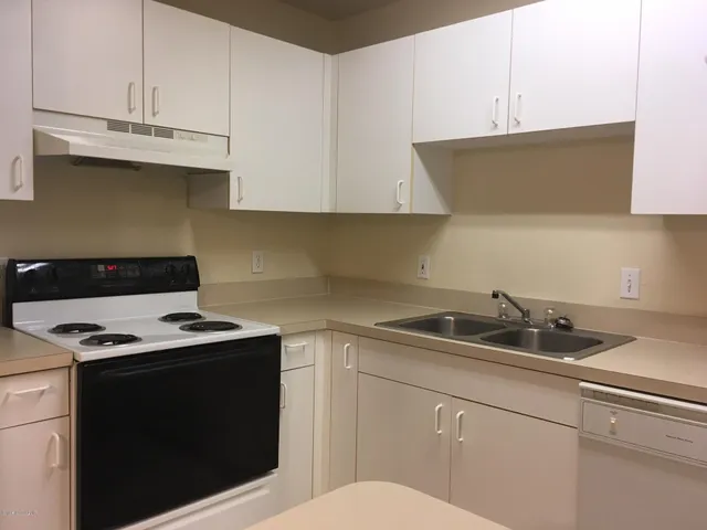 a kitchen with granite countertop white cabinets and white appliances