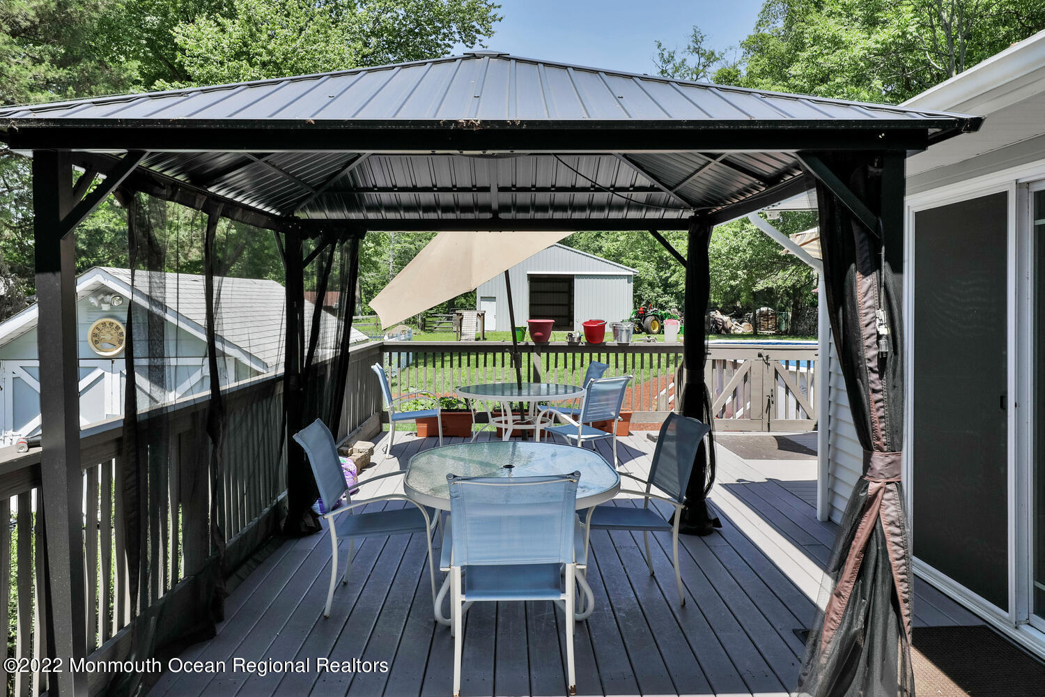 104 Peskin Road Farmingdale, NJ 07727 - Photo 24 of 54 a view of deck with table and chairs under an umbrella with wooden floor