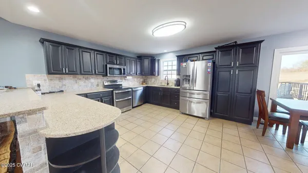 a kitchen with stainless steel appliances granite countertop a refrigerator sink and cabinets