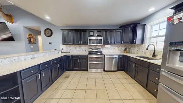 a kitchen with a sink a stove top oven and cabinets