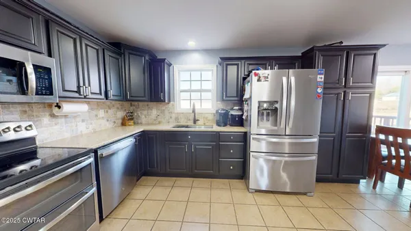 a kitchen with granite countertop a refrigerator and a sink