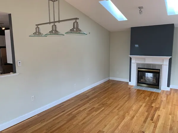 a view of empty room with wooden floor and fireplace
