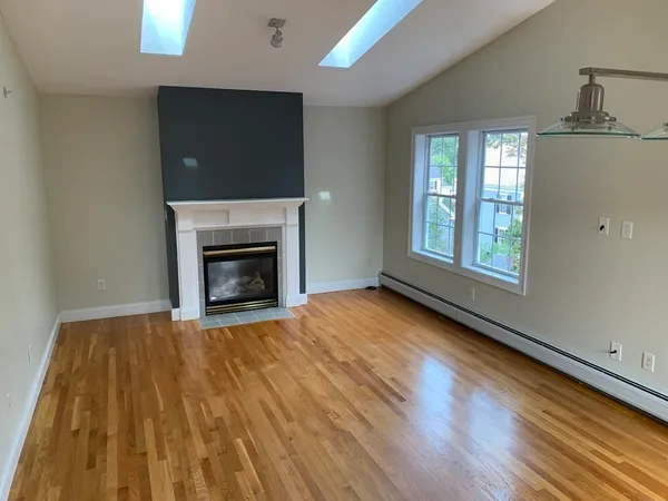wooden floor fireplace and windows in an empty room