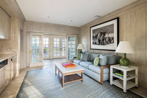 a living room with furniture and a painting on the wall