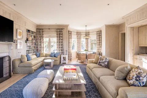 a living room with furniture a flat screen tv and a large window