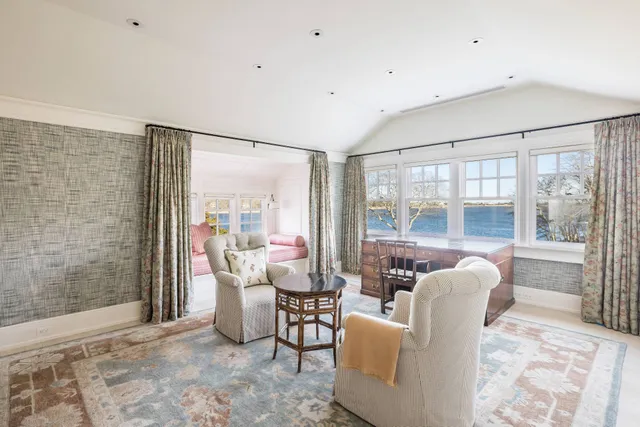 a living room with furniture and large windows