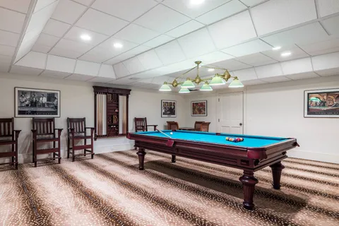 a room with pool table and windows