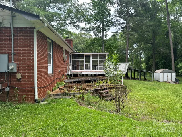 a view of a chair and table in backyard of the house