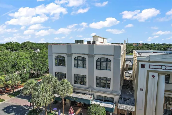 an aerial view of a city with lots of residential buildings ocean and mountain view in back