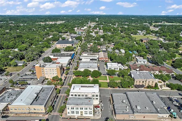 an aerial view of residential houses with outdoor space and trees