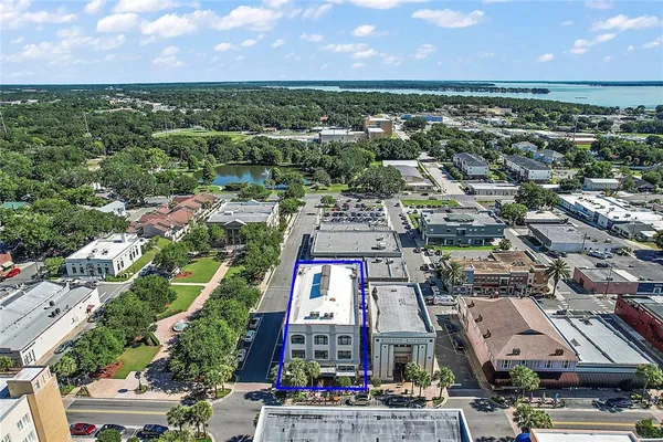 an aerial view of a city with lots of residential buildings ocean and mountain view in back