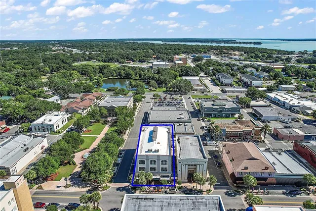an aerial view of a city with lots of residential buildings ocean and mountain view in back