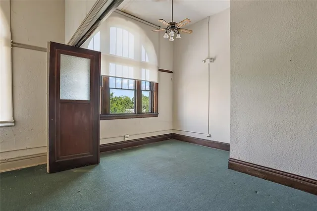 an empty room with windows and closet