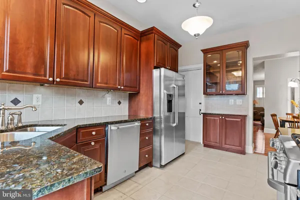 a kitchen with stainless steel appliances granite countertop a refrigerator and a stove top oven