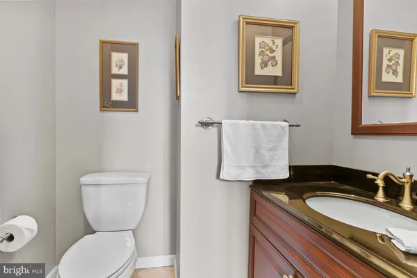 a bathroom with a granite countertop toilet sink and mirror