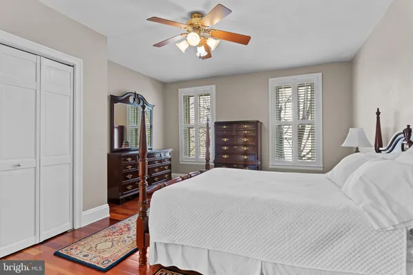 a bedroom with a bed a dresser and potted plant