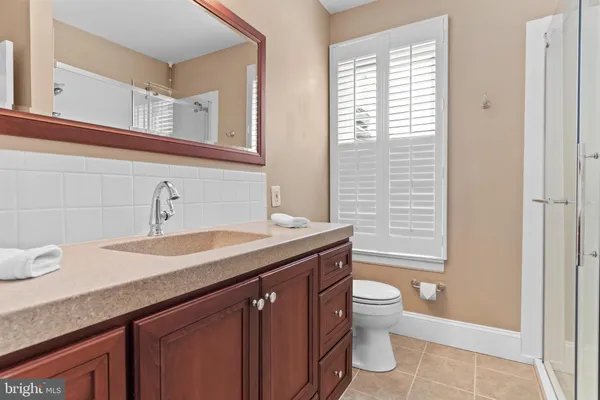 a bathroom with a granite countertop sink a toilet and a mirror