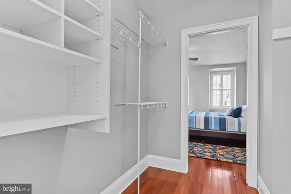 a view of walk in closet with wooden floor