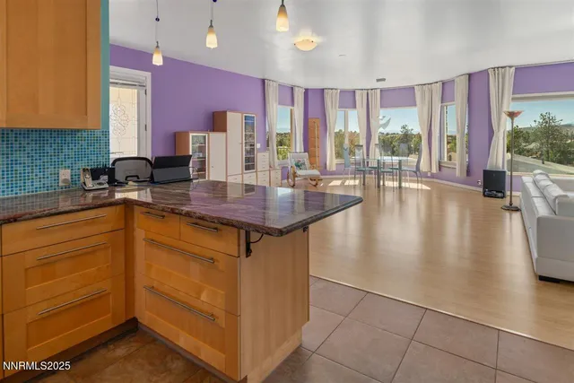 a kitchen with stainless steel appliances granite countertop a sink counter space and living room view