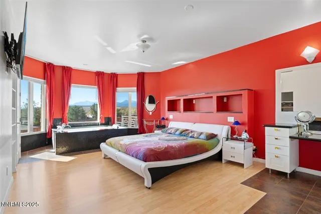 a bedroom with a bed and large windows