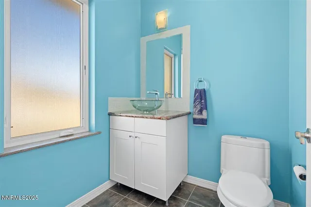 a bathroom with a granite countertop toilet sink and mirror