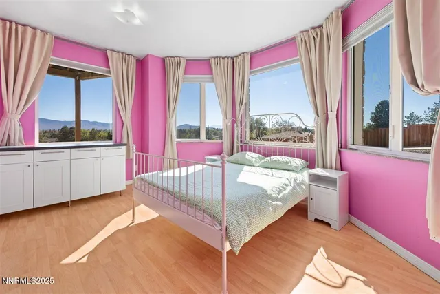 a spacious bedroom with a bed and wooden floor