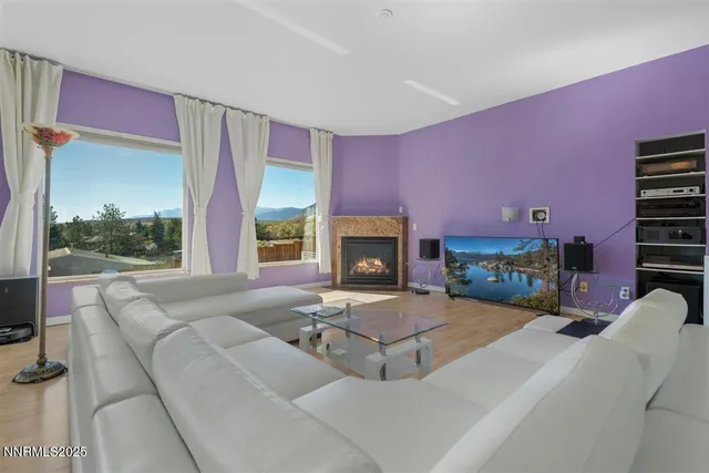 a living room with furniture a fireplace and a floor to ceiling window