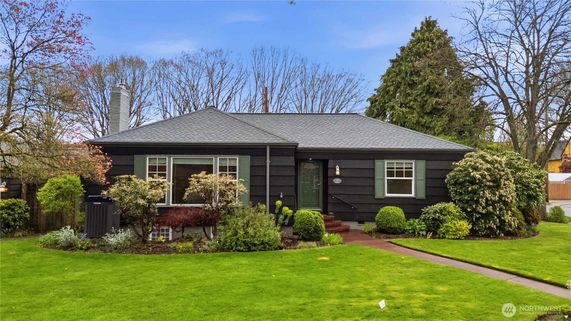 a front view of a house with plants and garden