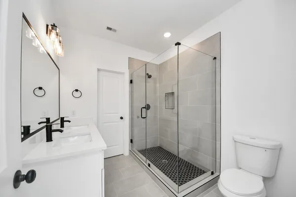a bathroom with a double vanity sink mirror and