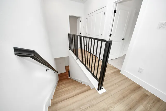 a view of a hallway with wooden floor and staircase
