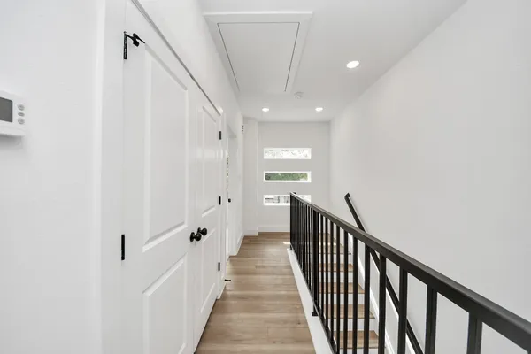 an empty room with ceiling fan and windows