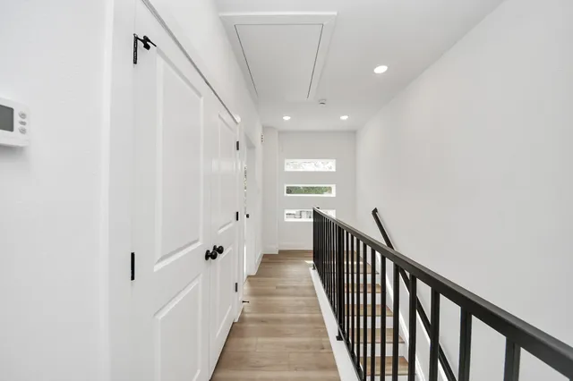 a view of a hallway with wooden floor and entryway
