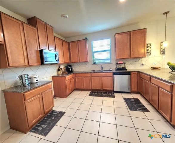 a kitchen with stainless steel appliances granite countertop a sink and cabinets