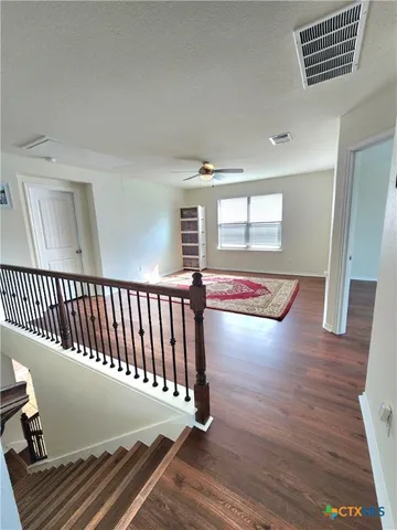 a view of a hallway with wooden floor