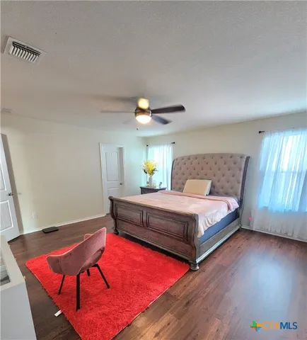 a bedroom with a bed and a lamp on dresser